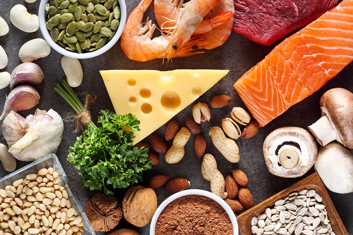 Foods High in Zinc as salmon, seafood-shrimps, beef, yellow cheese, parsley leaves, mushrooms, cocoa, pumpkin seeds, garlic, bean, almonds, pine nut. Top view